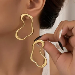Brinco médio com formato orgânico de aço cirúrgico folheado a ouro.